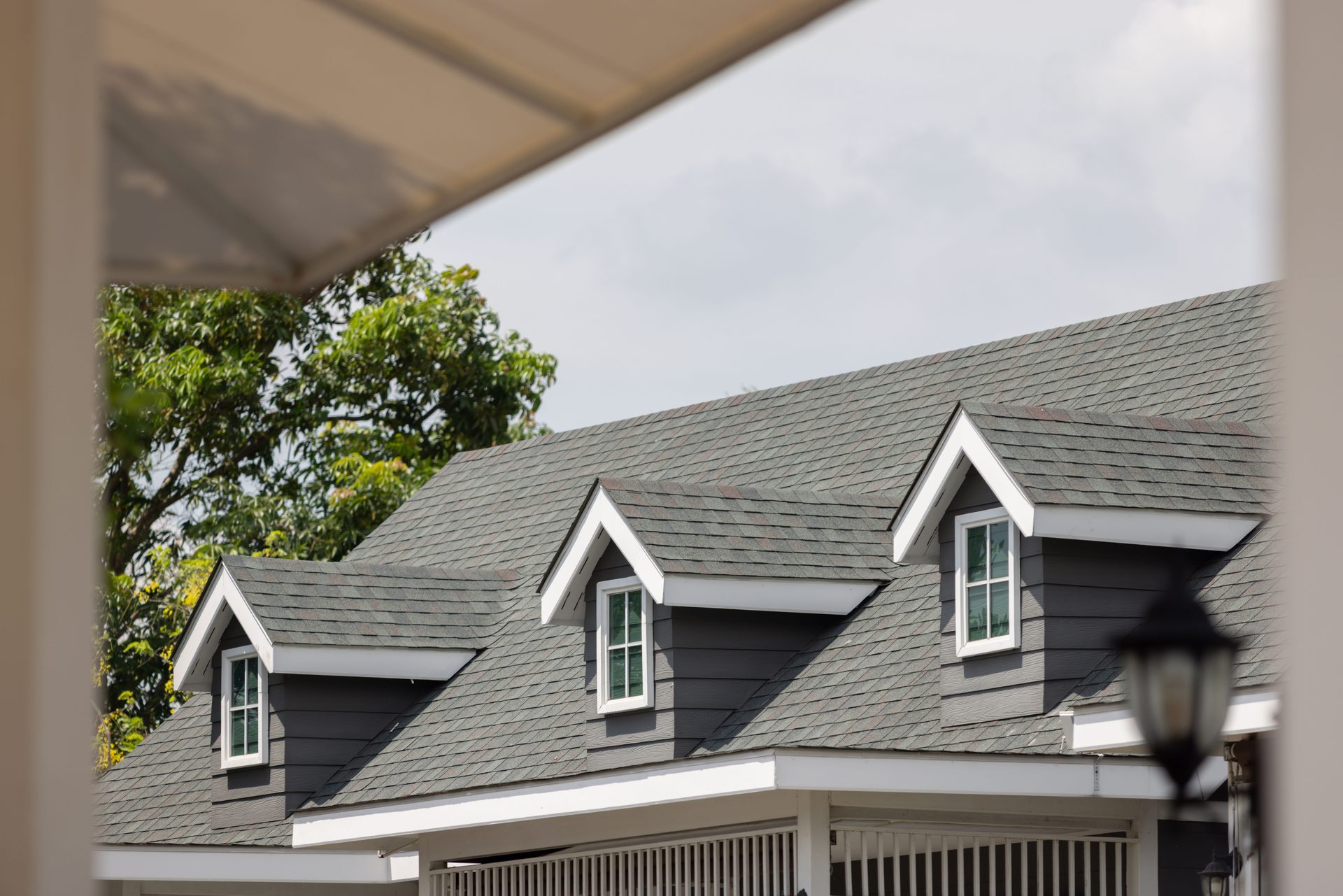 Close detail of dormer windows and a shingle roofline