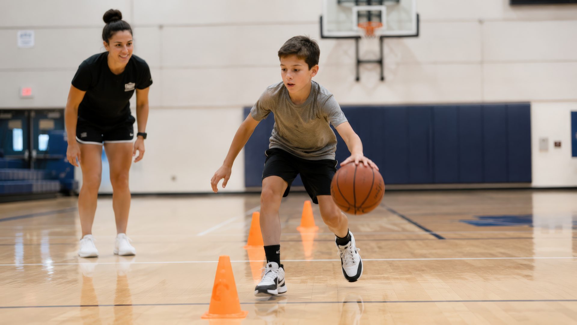 Young athlete dribbling a basketball through agility cones with a Breakaway trainer