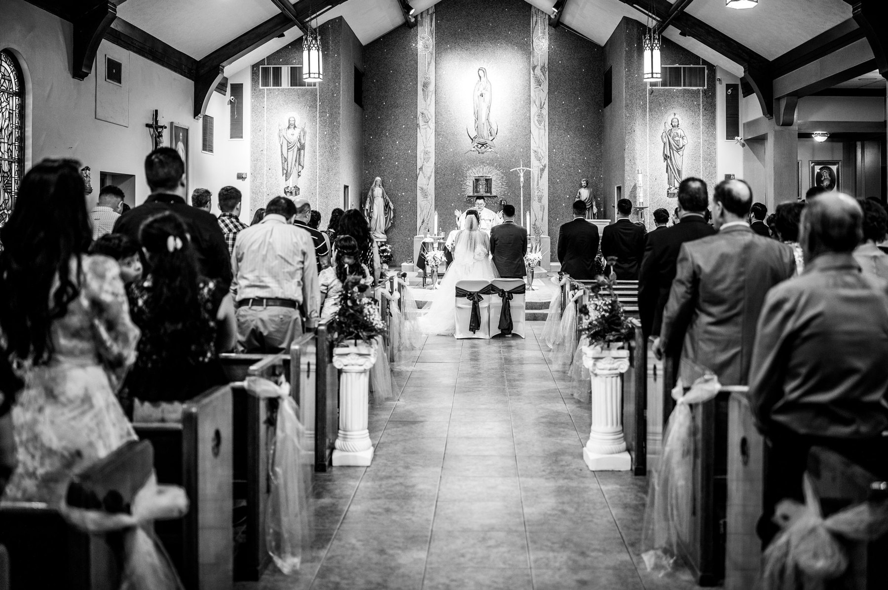 Wedding ceremony inside a church, guests watching the couple at the altar