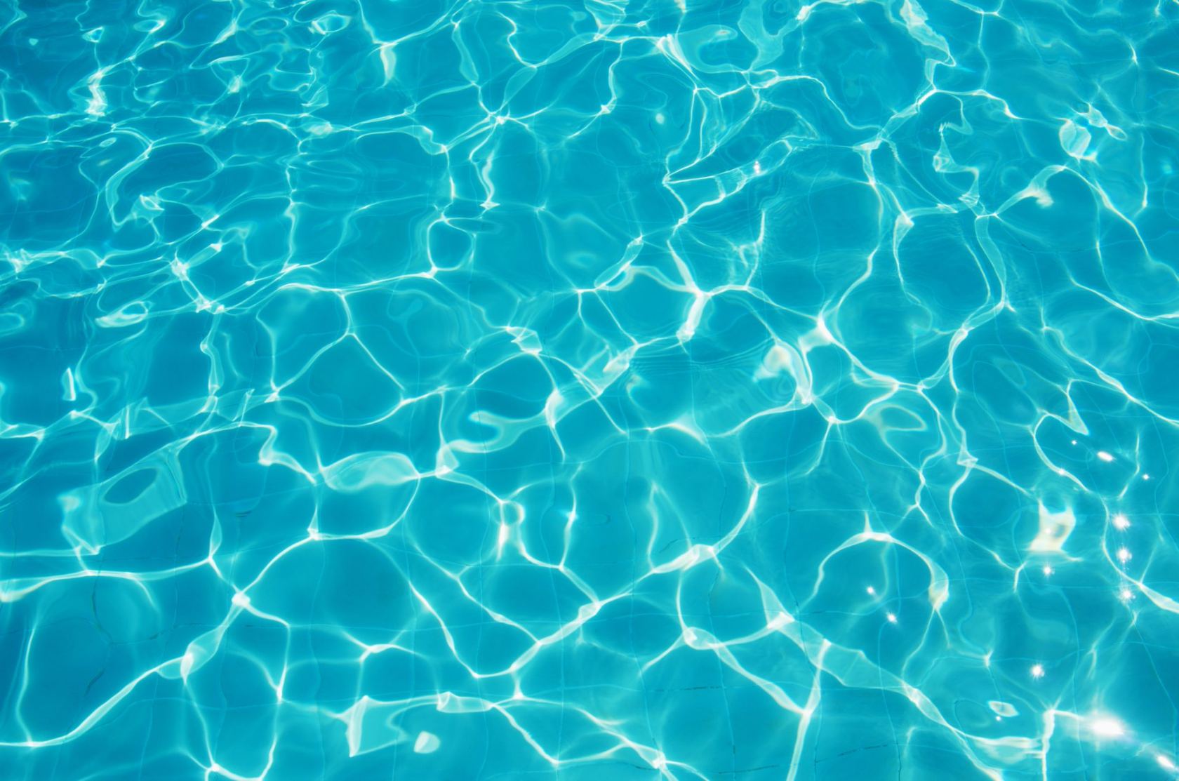 Sunlit caustics rippling across clean pool water