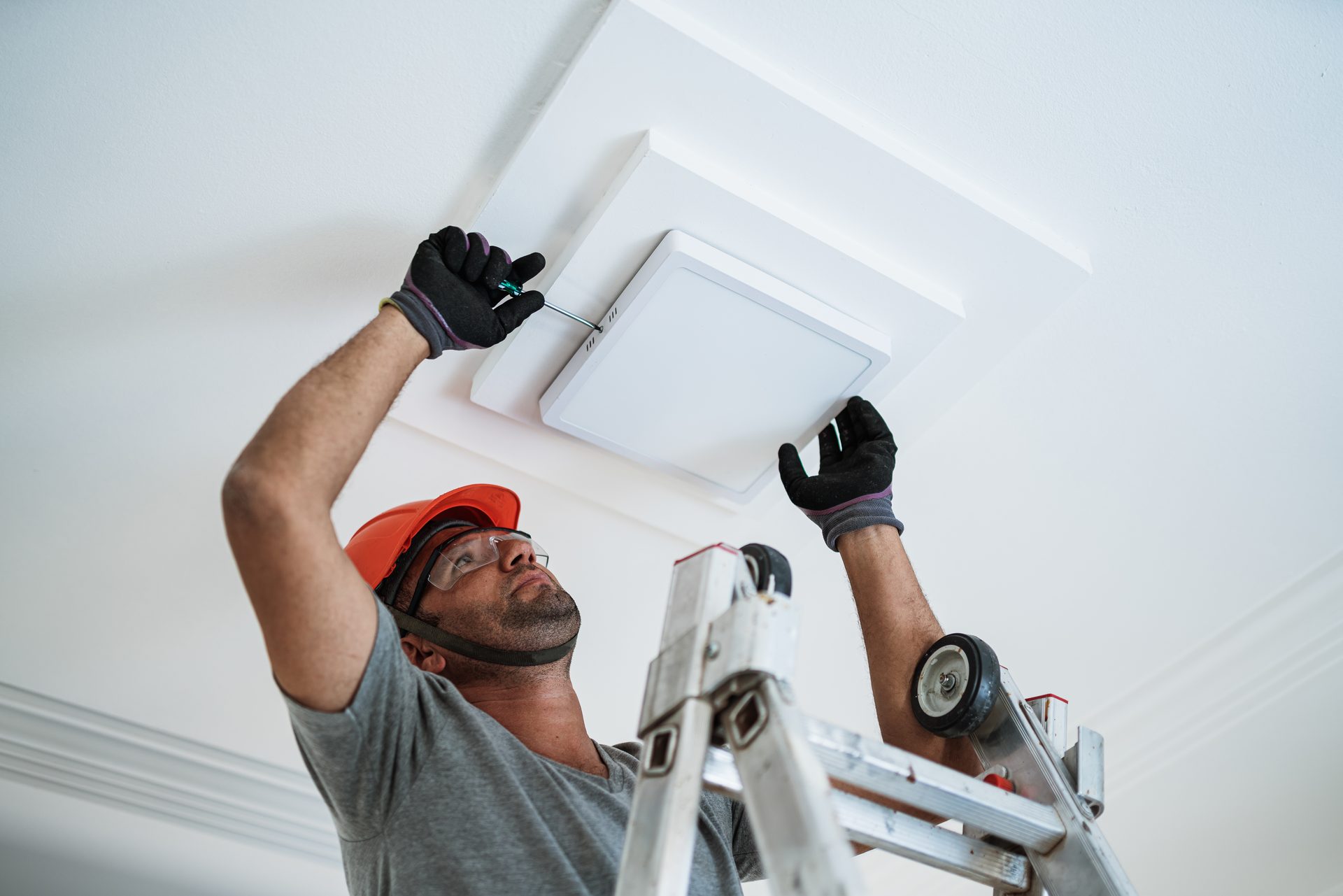 Voltline electrician installing an LED ceiling light, brought to code